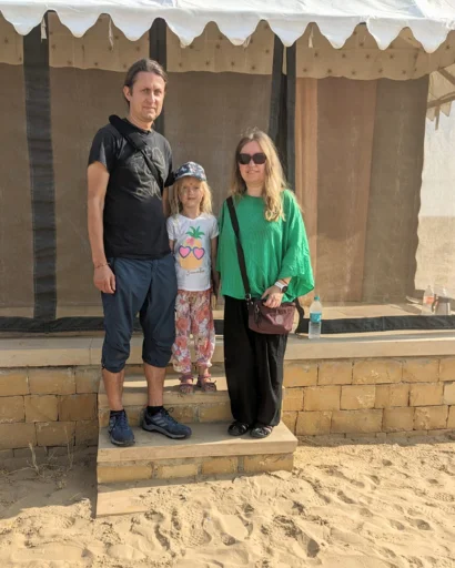 Family of three posing in front of their tent