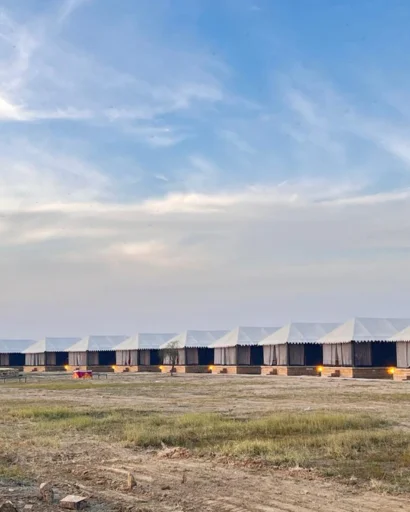 Long row of white tents beneath a wide blue sky