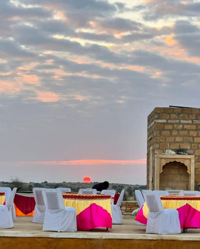 Outdoor dining tables set for dinner as the sun sets