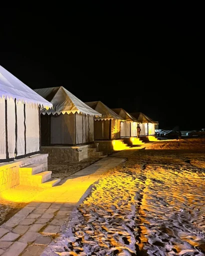 Tents along a lit pathway after dark