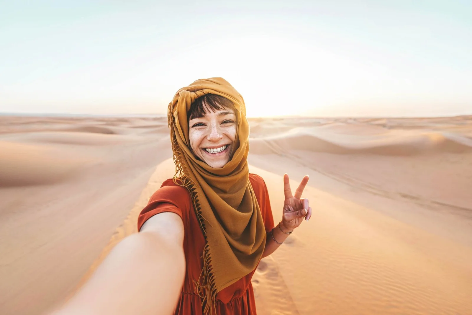 Smiling traveller taking a selfie among the dunes
