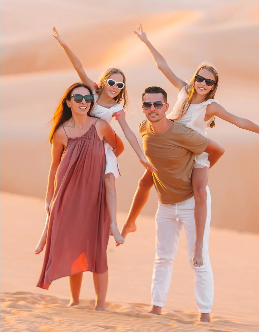 Family jumping together on a sand dune